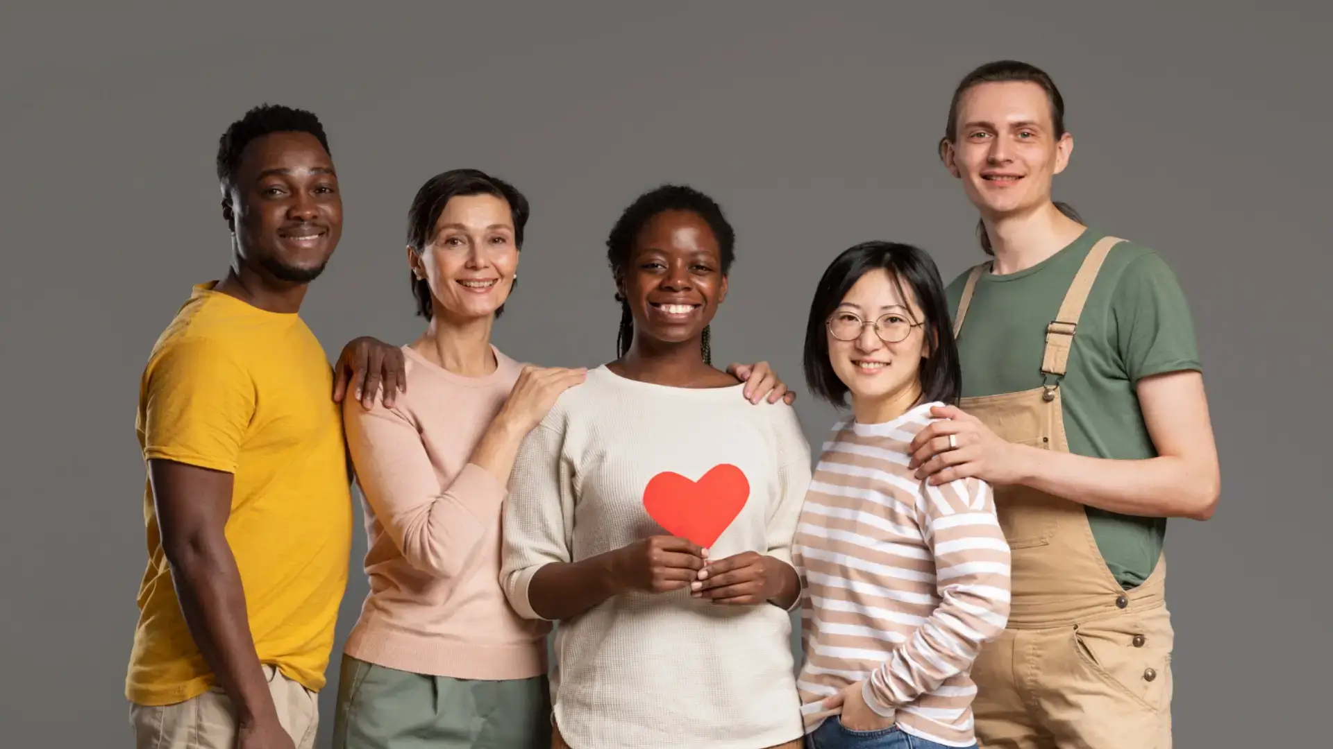 Diverse group holding a red heart.